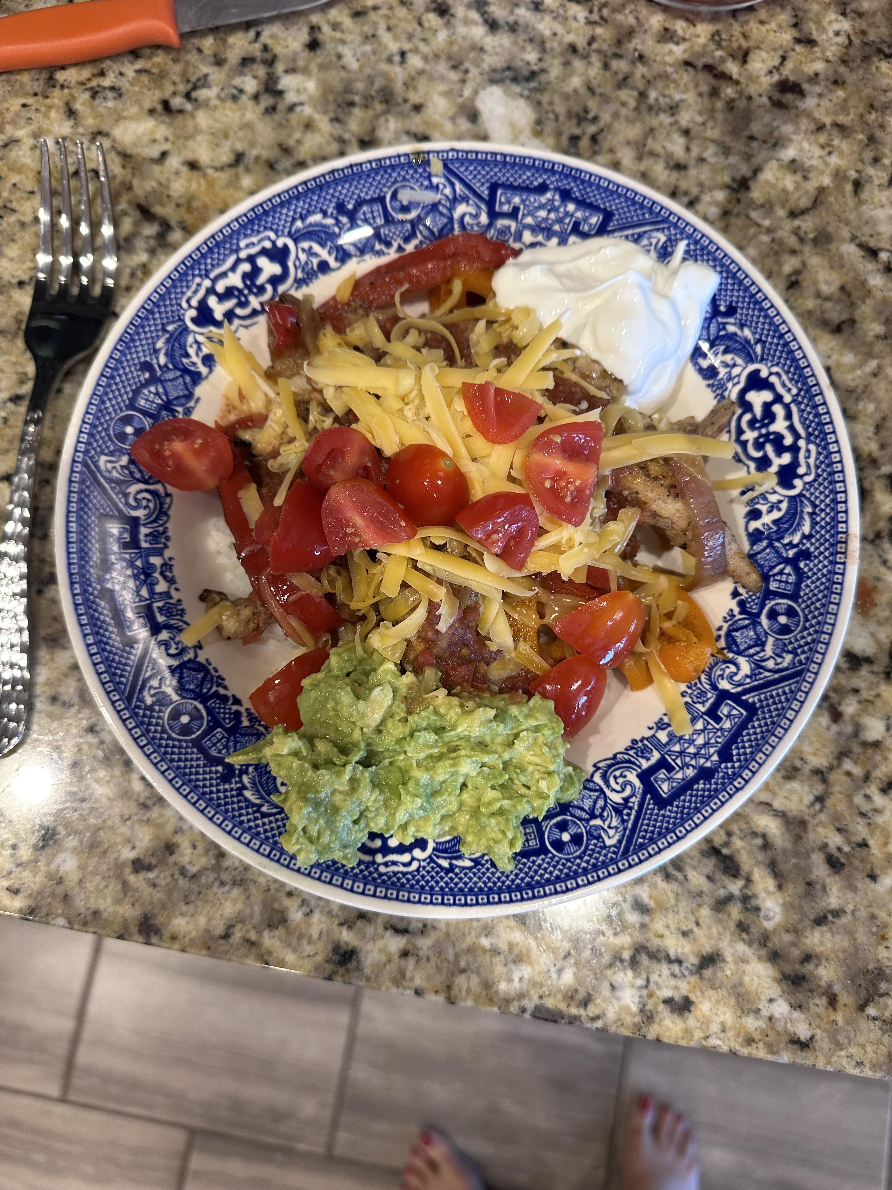 A fajita plate served on a blue and white Blue Willow patterned plate