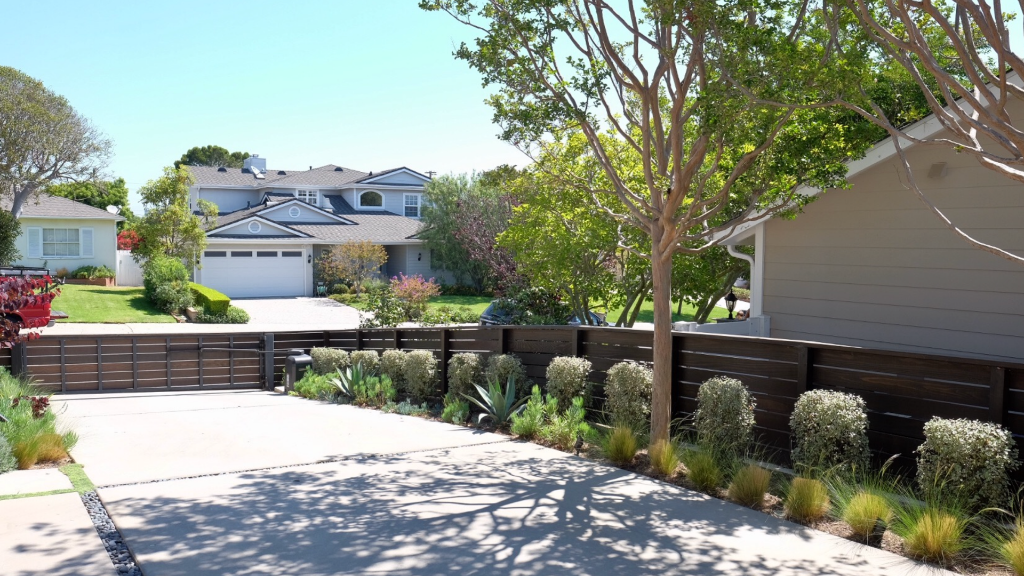 Front yard redesign — drought-tolerant planting, horizontal wood fence, concrete driveway