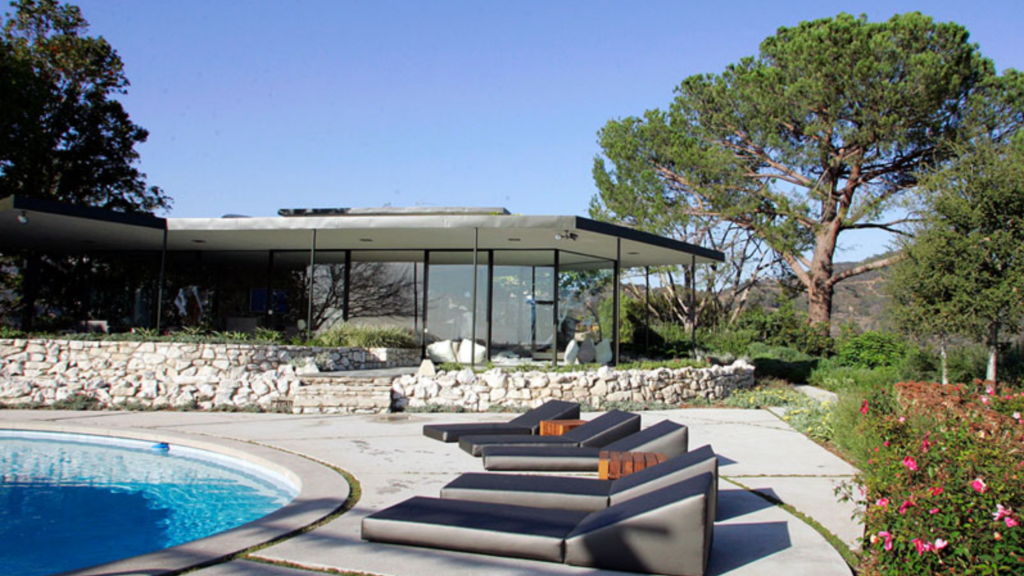 Mid-century pool garden — stone retaining wall, cantilevered pavilion, coastal and rose planting