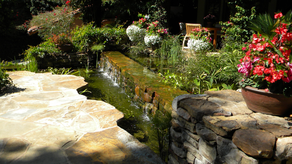 Water channel detail — cascading water, stone coping, and seasonal flower planting