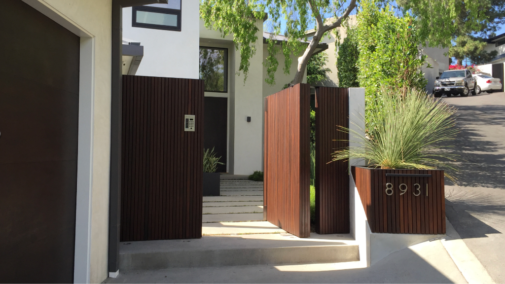 Modern entry gate — hardwood slatted gate, corten planter with yucca, concrete threshold steps