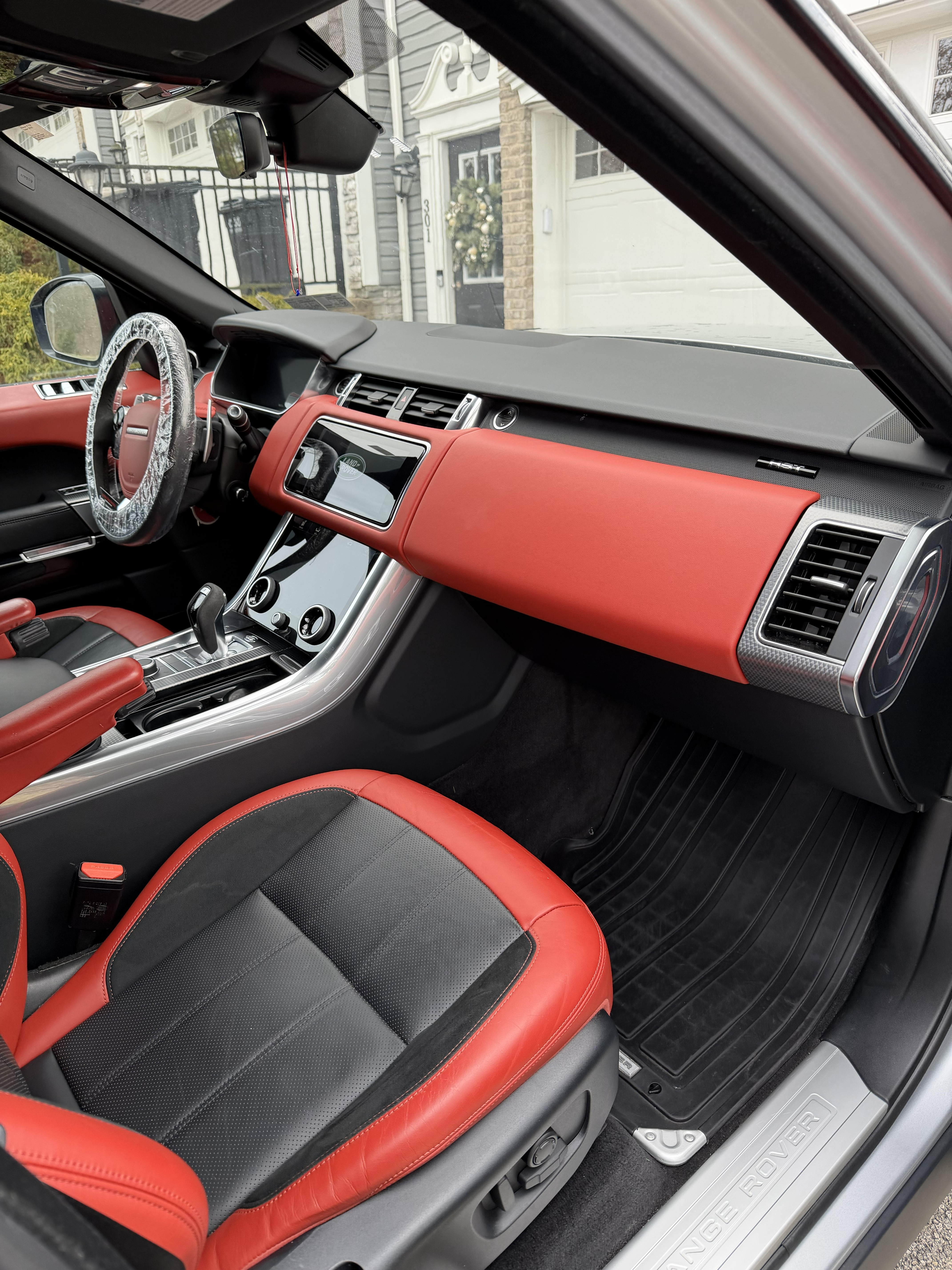 Red and black Range Rover interior detailing showing dashboard, steering wheel, and conditioned leather seats by Landen's Mobile Detailing