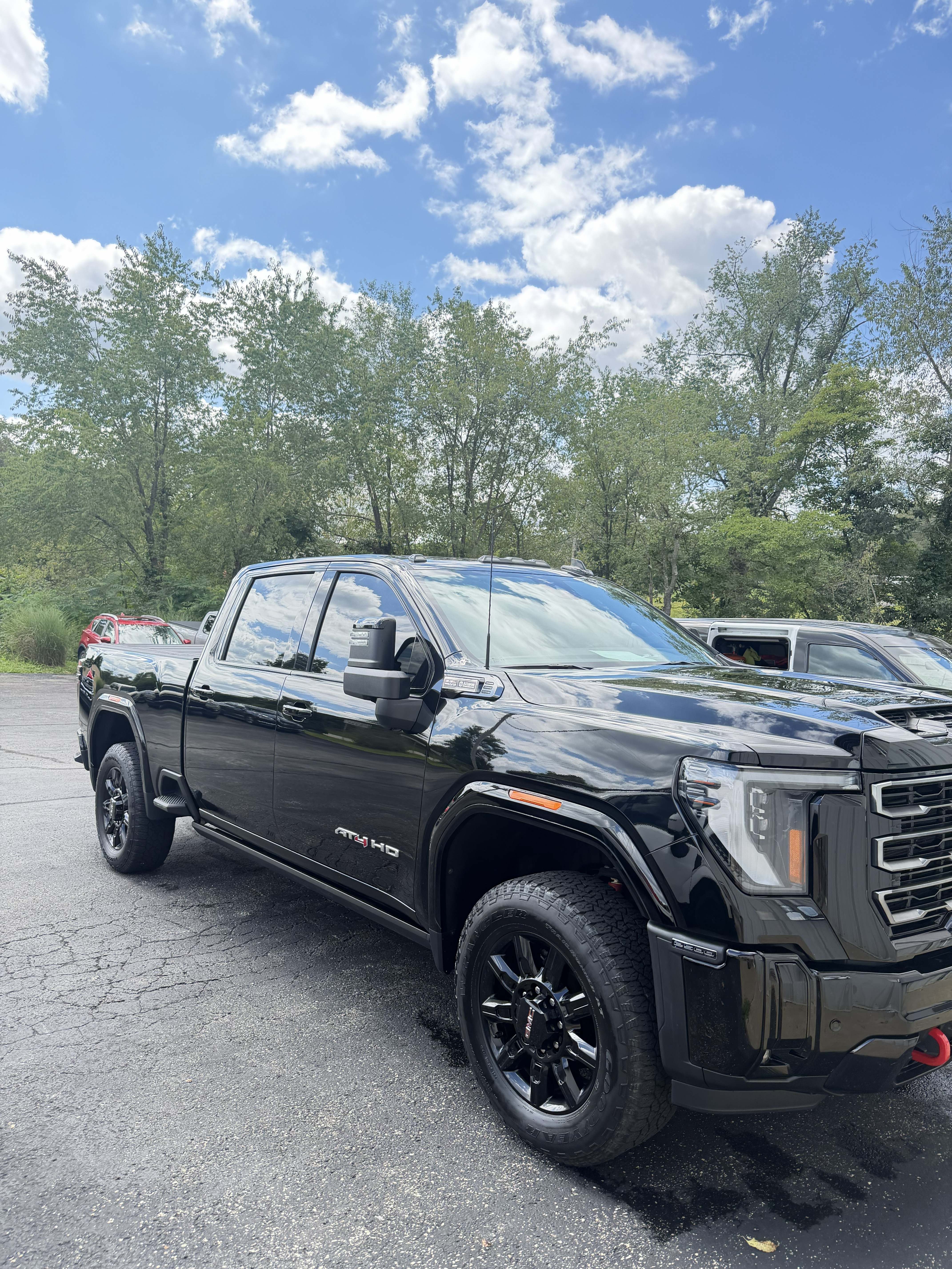 Black GMC Sierra AT4 HD pickup truck washed and waxed with a glossy reflective finish in Freeport, PA