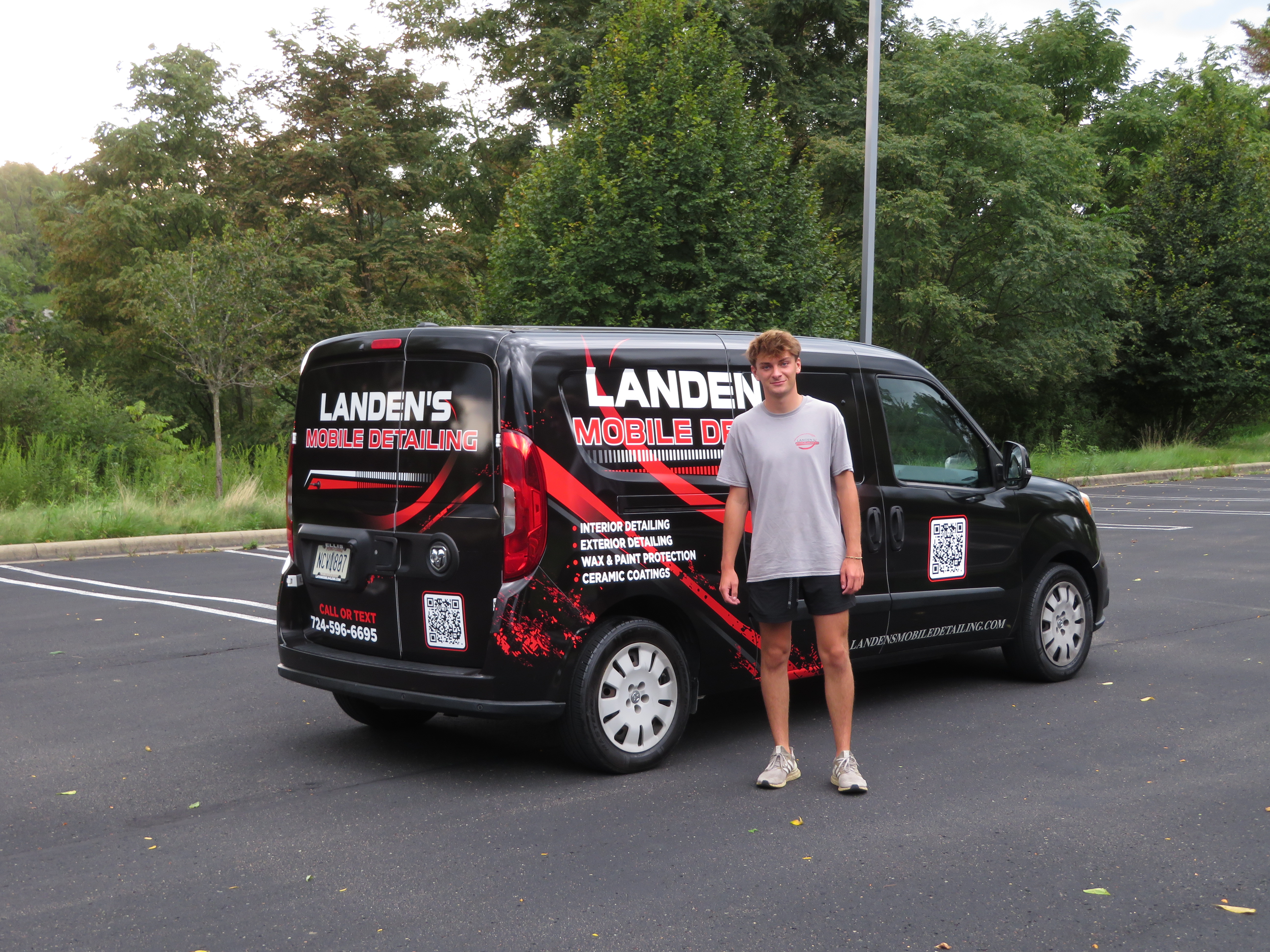 Landen standing in front of the Landen's Mobile Detailing branded van listing interior, exterior, wax & paint protection, and ceramic coating services