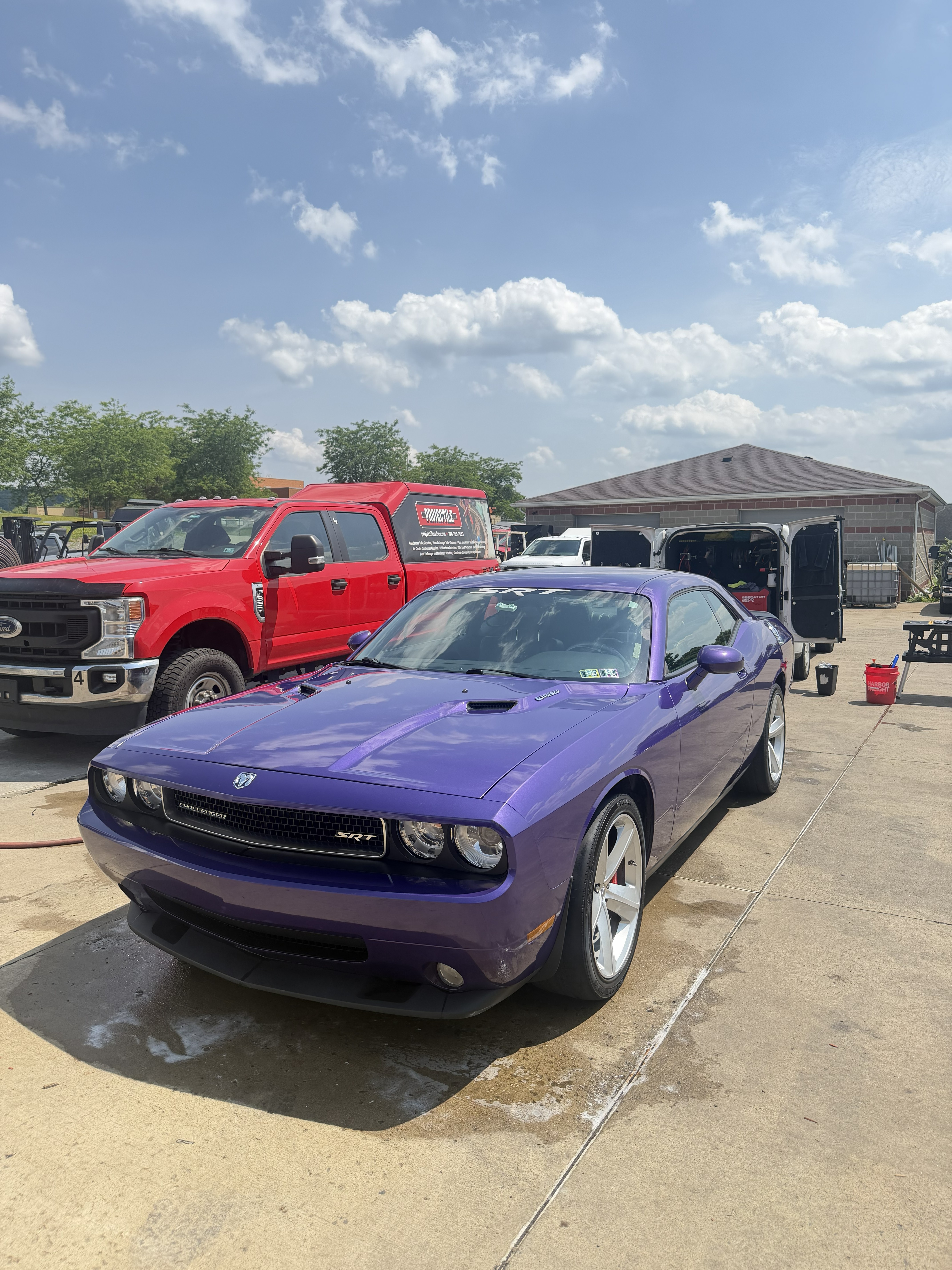 Purple Dodge Challenger SRT full detail with mobile detailing van open behind it in Ford City, PA