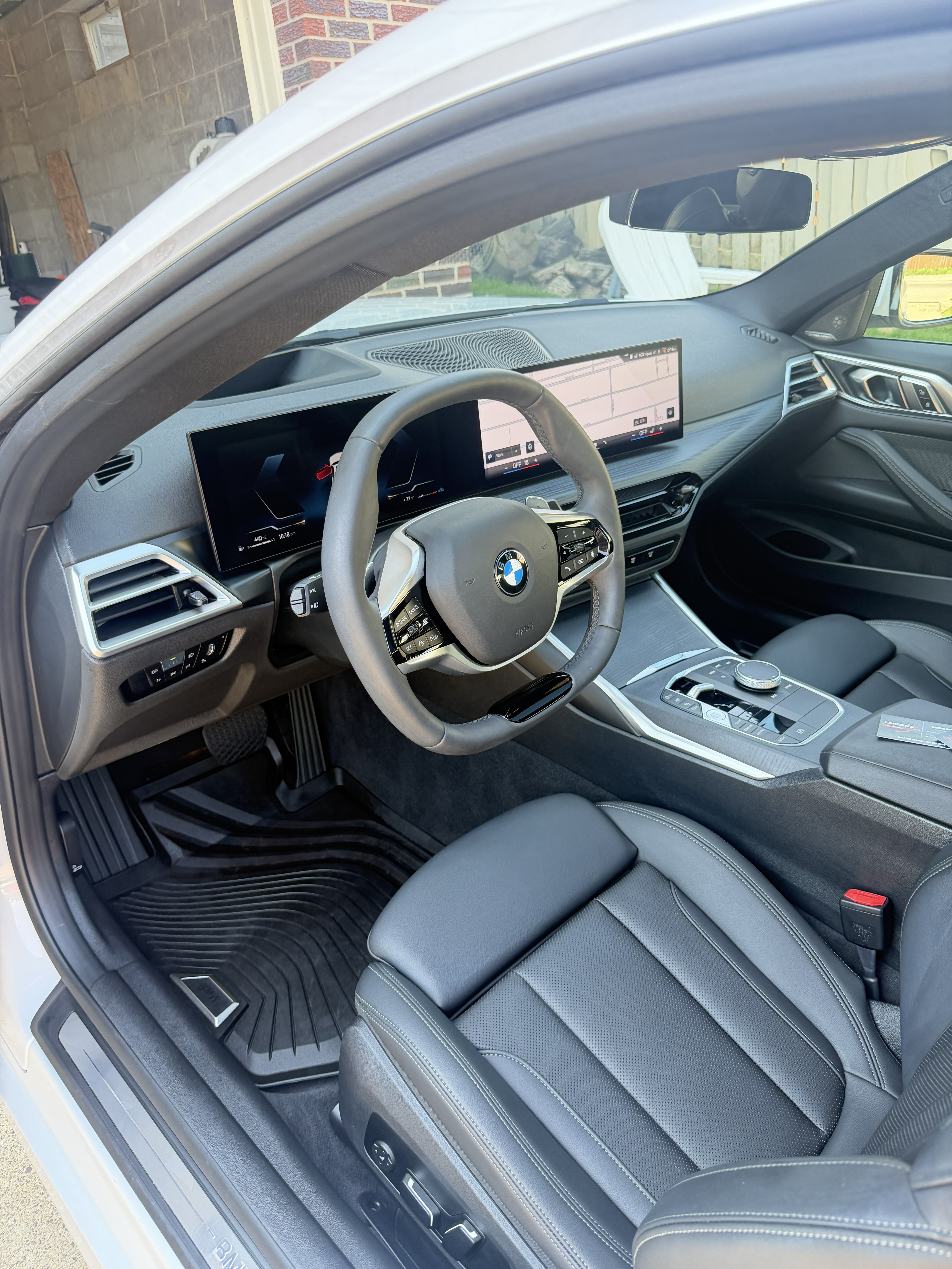 BMW interior cockpit detailing showing cleaned steering wheel, panoramic display, and conditioned leather seat