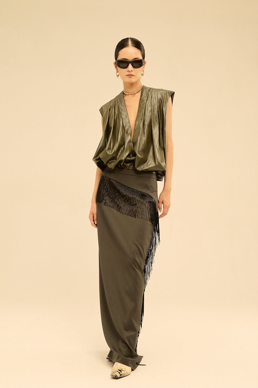 Editorial fashion — metallic olive-green ensemble with fringe skirt