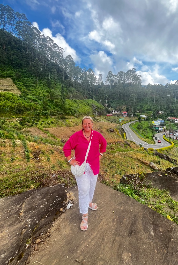 Kerry standing in the Sri Lanka highlands with lush green tea country landscape.
