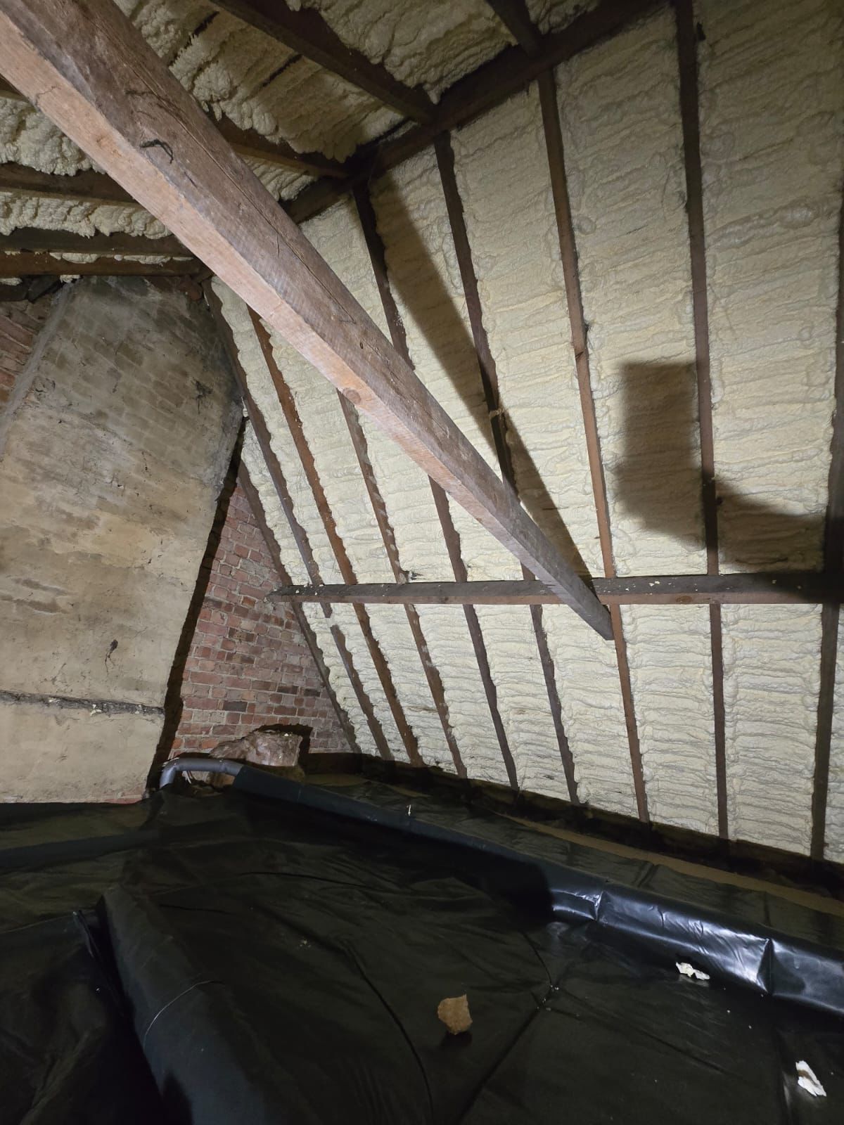 Loft with spray foam insulation before removal – Loft, Surrey – open-cell foam removed
