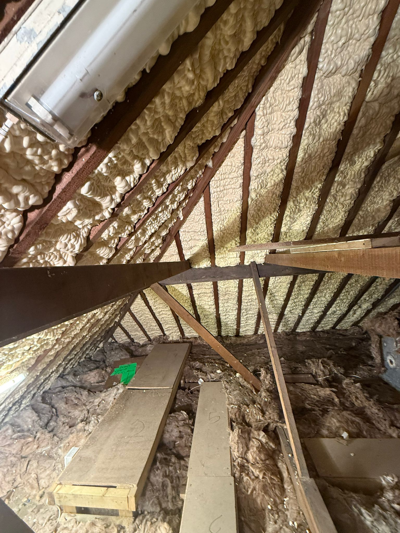 Loft before removal — dense open-cell spray foam covering roof timbers