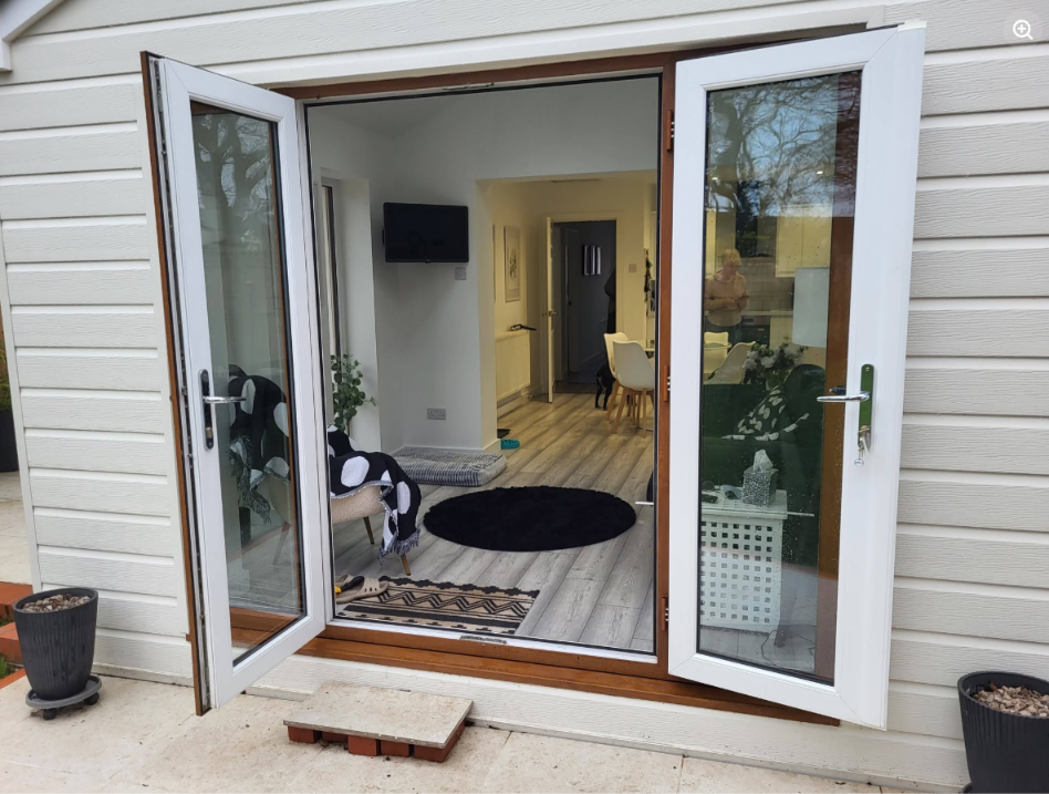 Open French doors looking out from the extension living space onto the garden and patio