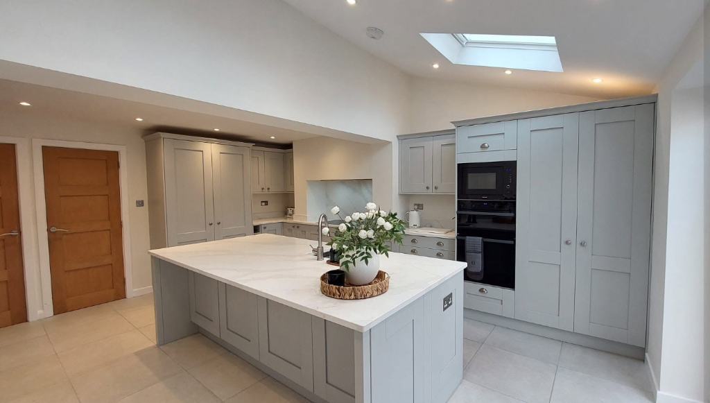 Classic grey fitted kitchen with marble quartz island and skylight