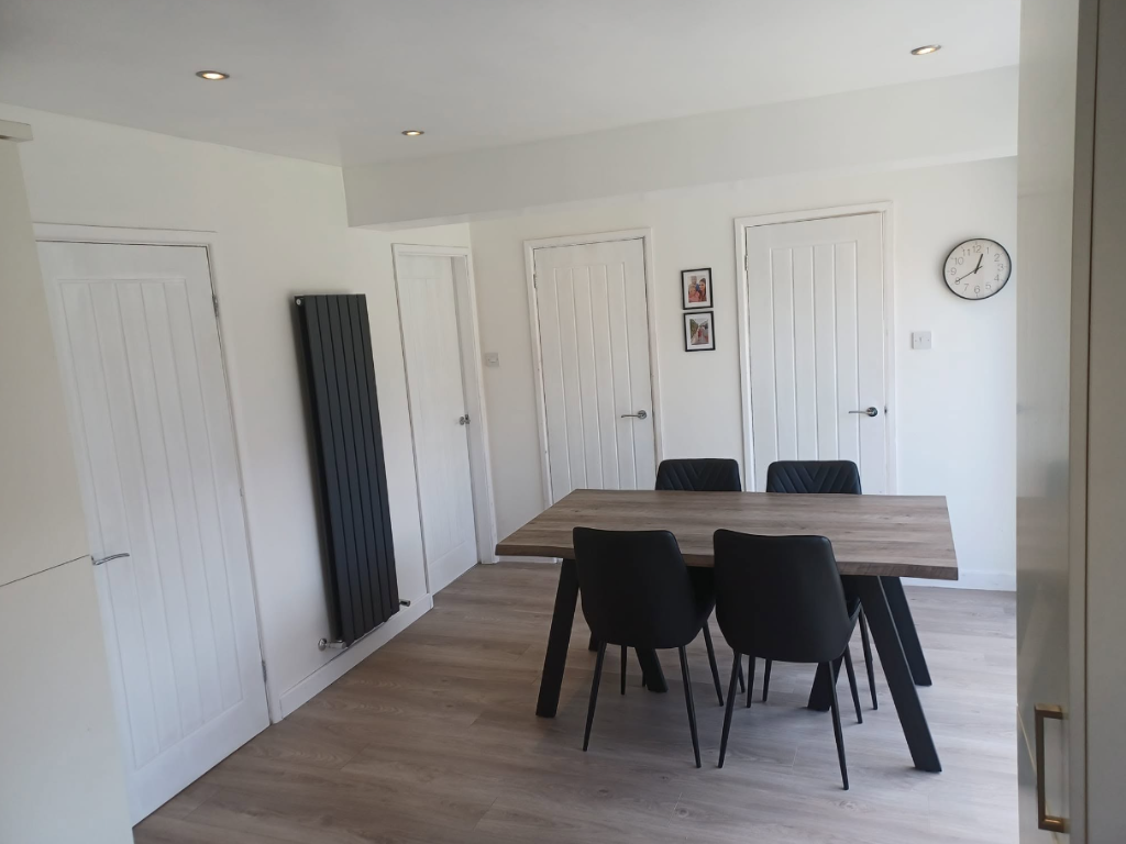 Bright dining room extension with bespoke panelled doors and herringbone flooring