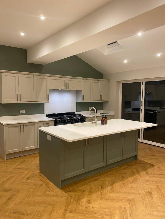 Sage green shaker kitchen with herringbone floor and large island