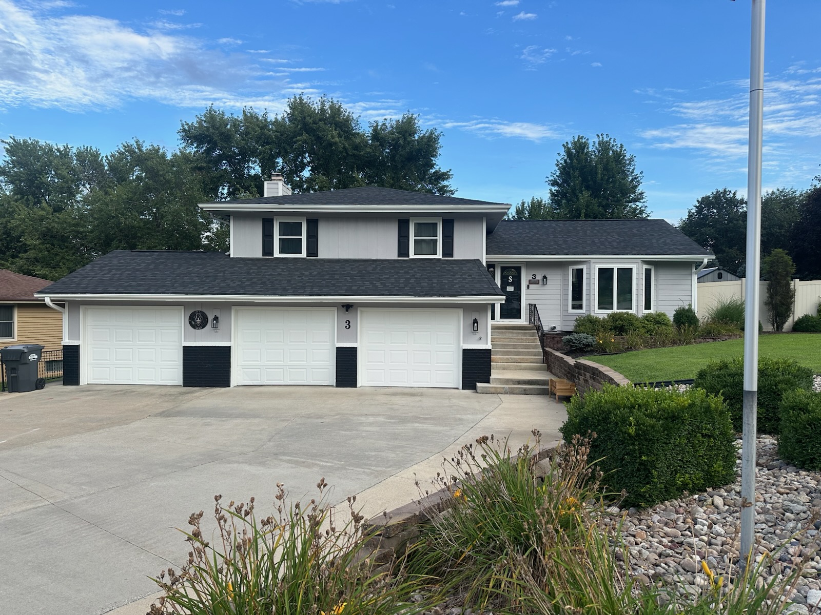 The same two-story home in daylight with no visible lighting hardware