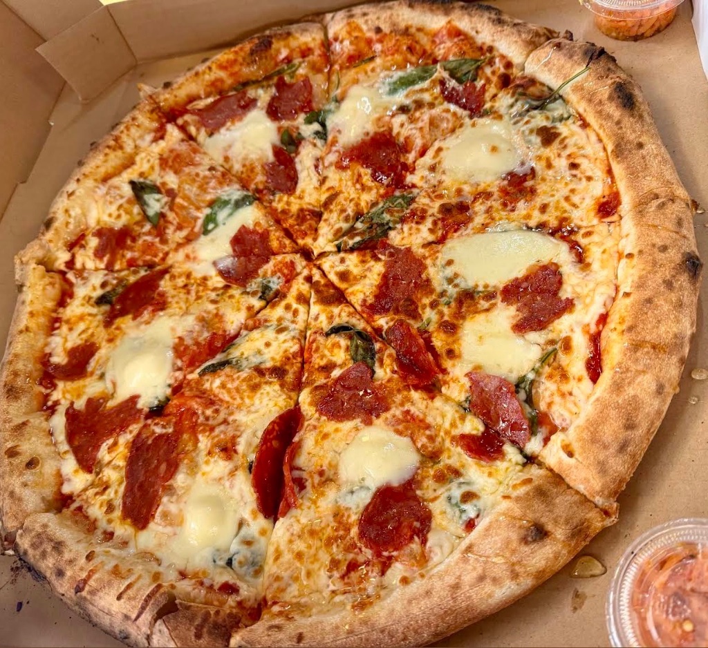 Wood-fired pizza with salami and basil