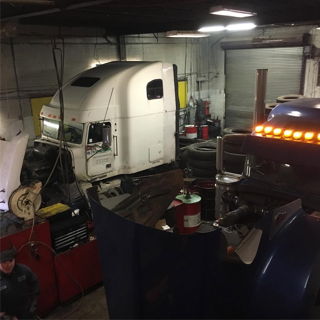 Two heavy-duty trucks inside the shop for service