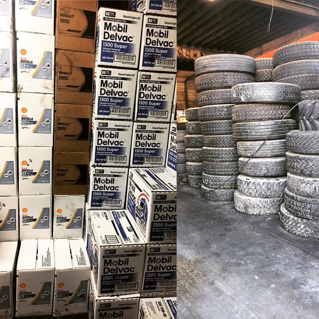 Diesel engine oil cases stacked beside a tall rack of tires