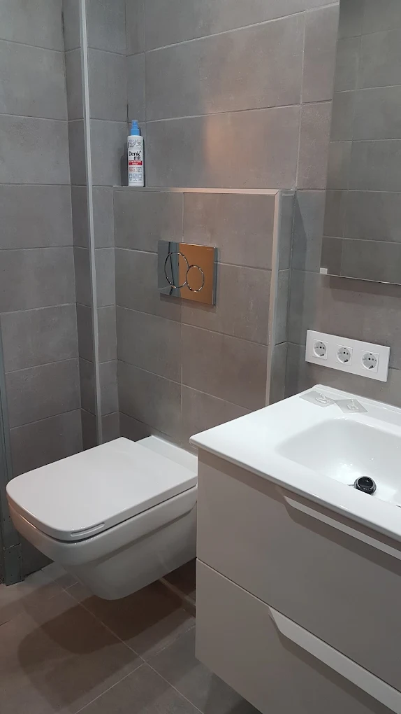 Baño gris con inodoro suspendido