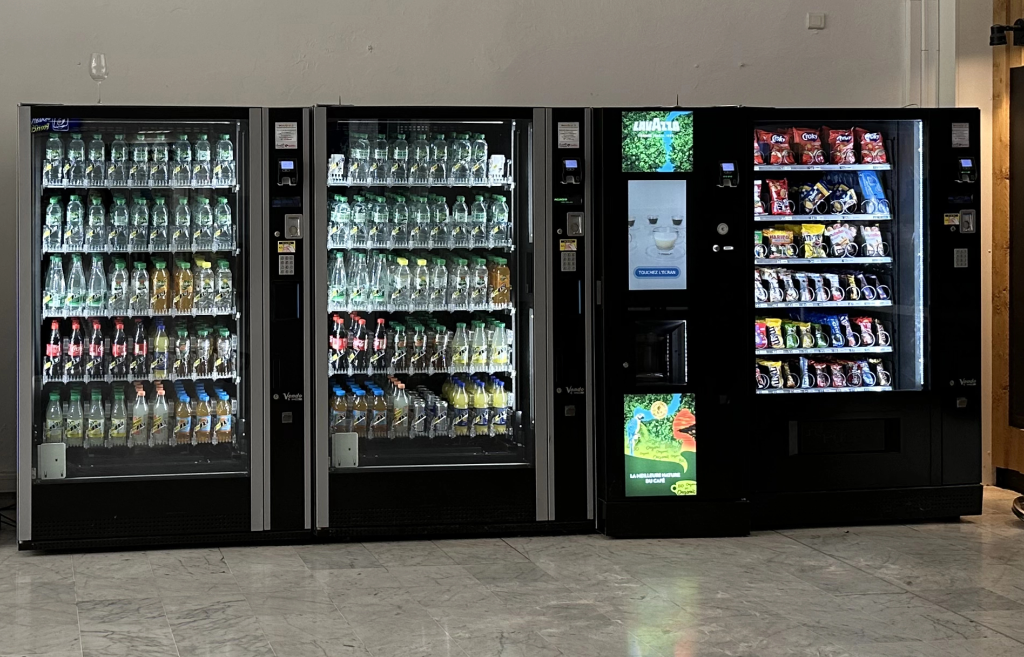 Wall of vending machines stocked with snacks and beverages