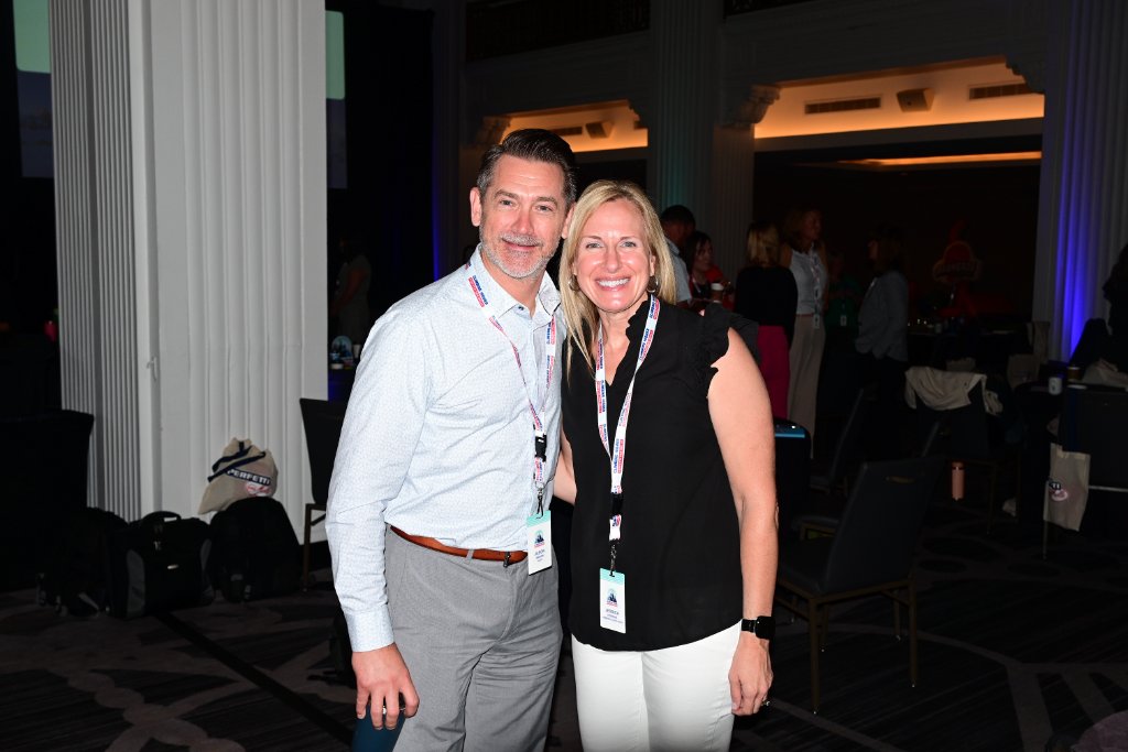 Two attendees posing together at a corporate event reception