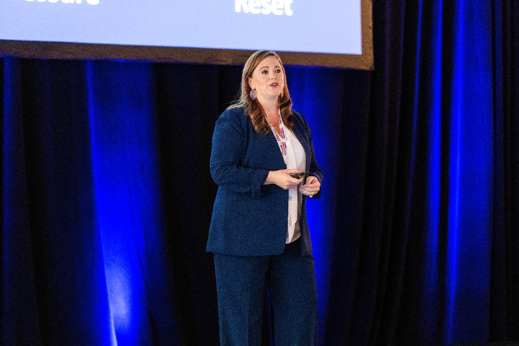 Professional speaker presenting on stage at a corporate conference