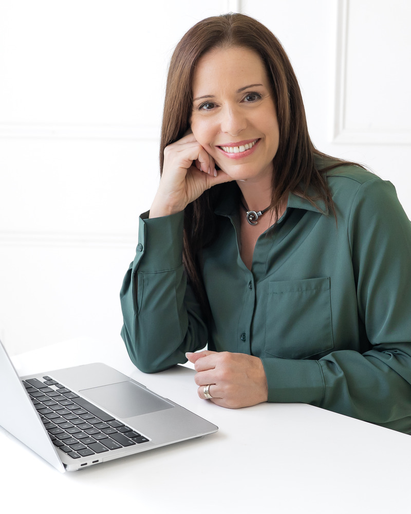 Einat at her desk with a laptop