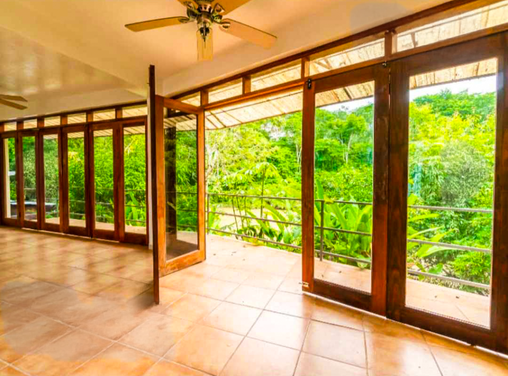 Open-air veranda with glass doors and panoramic forest views