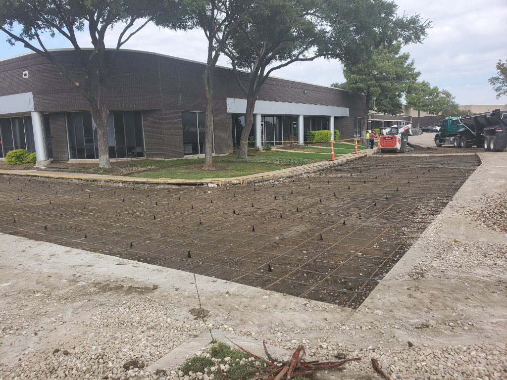 Crew smoothing concrete in commercial parking lot
