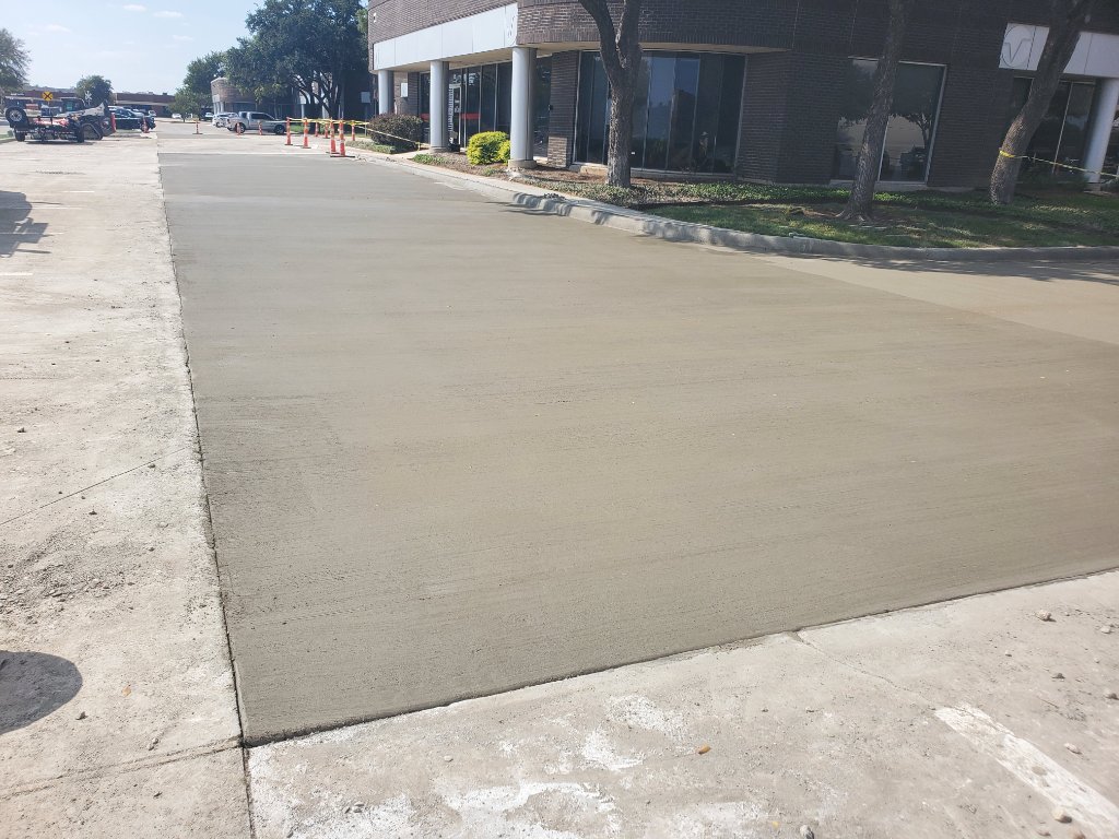 Concrete crew finishing a parking lot pour