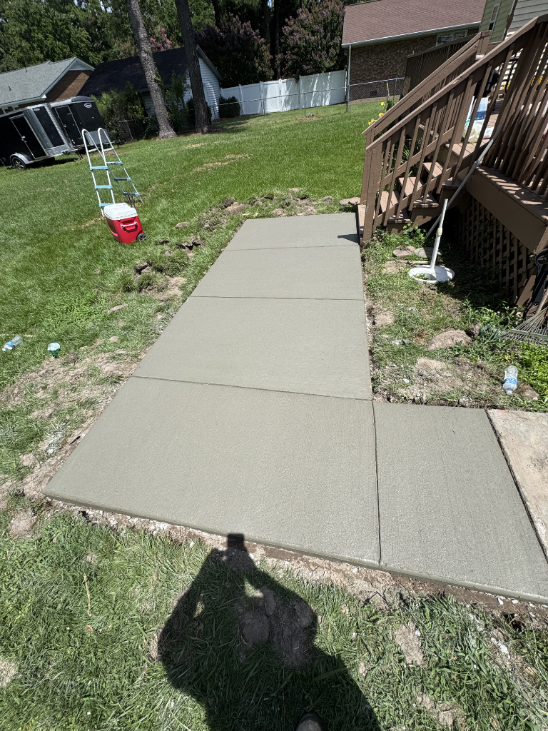 Completed concrete driveway project showing clean edges and broom finish