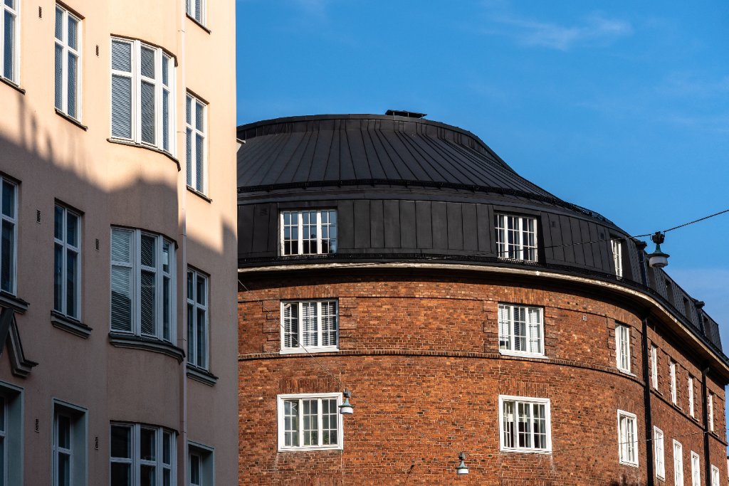 Murstensfacade med sort saddeltag og hvidskuret puds på moderne bolig