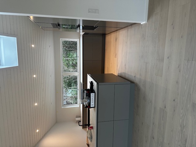 Nyt køkken med mørkegrå frontskabe og hvidmalet træbeklædning monteret af Evers Byg