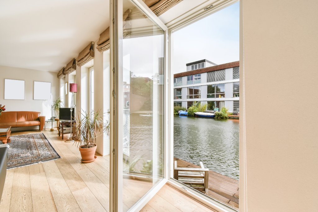 Stue med gulv-til-loft energiruder og franske døre med kanaludsigt
