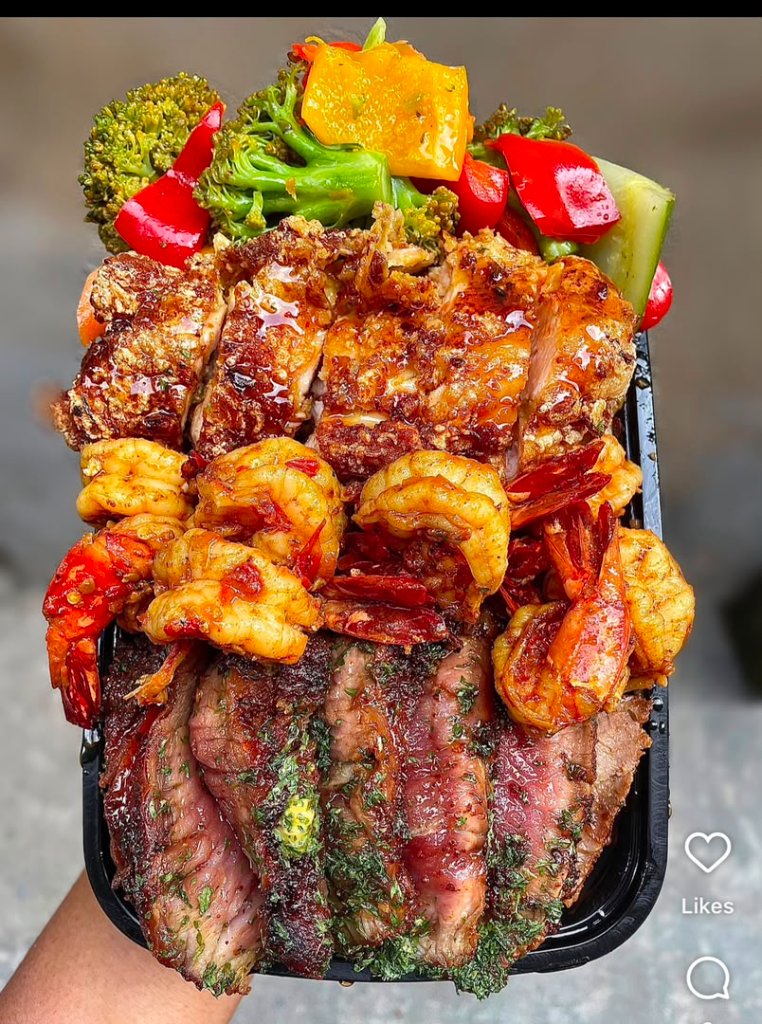 Steak and shrimp combo in a black takeout box