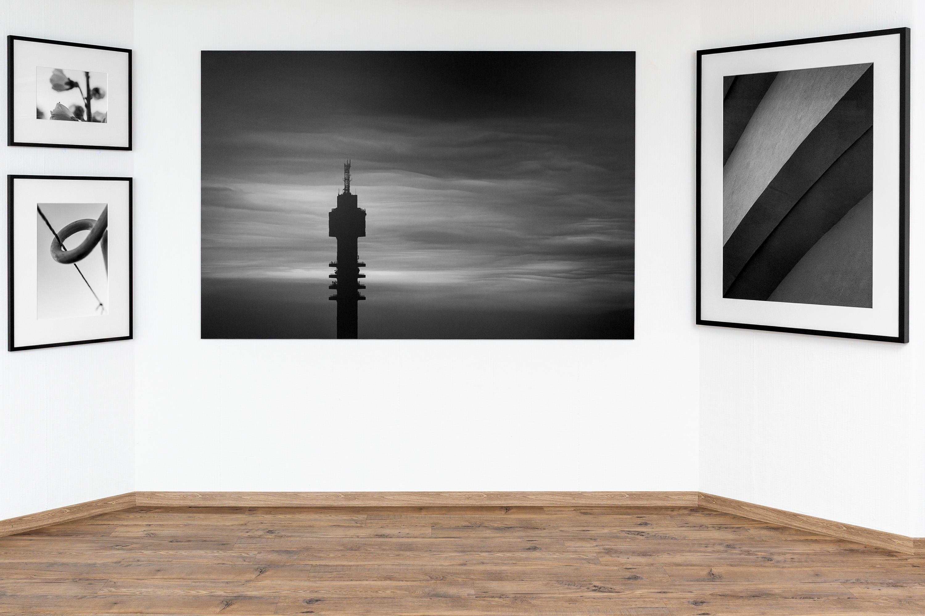 Galeriewand mit gerahmten Schwarz-Weiss-Fotografien auf weisser Wand