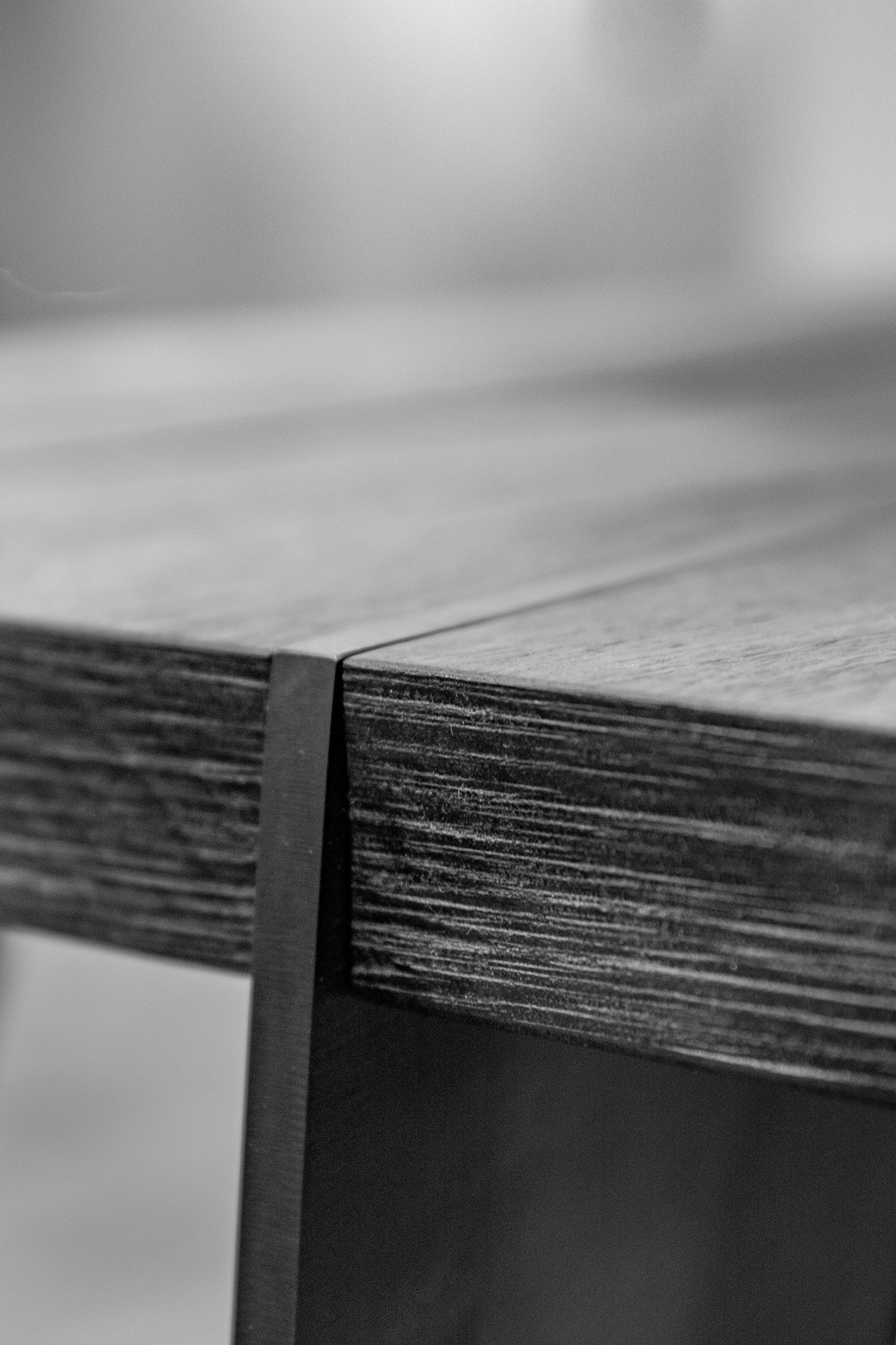 Detailaufnahme einer Holzstruktur mit dunkler Metalleinlage
