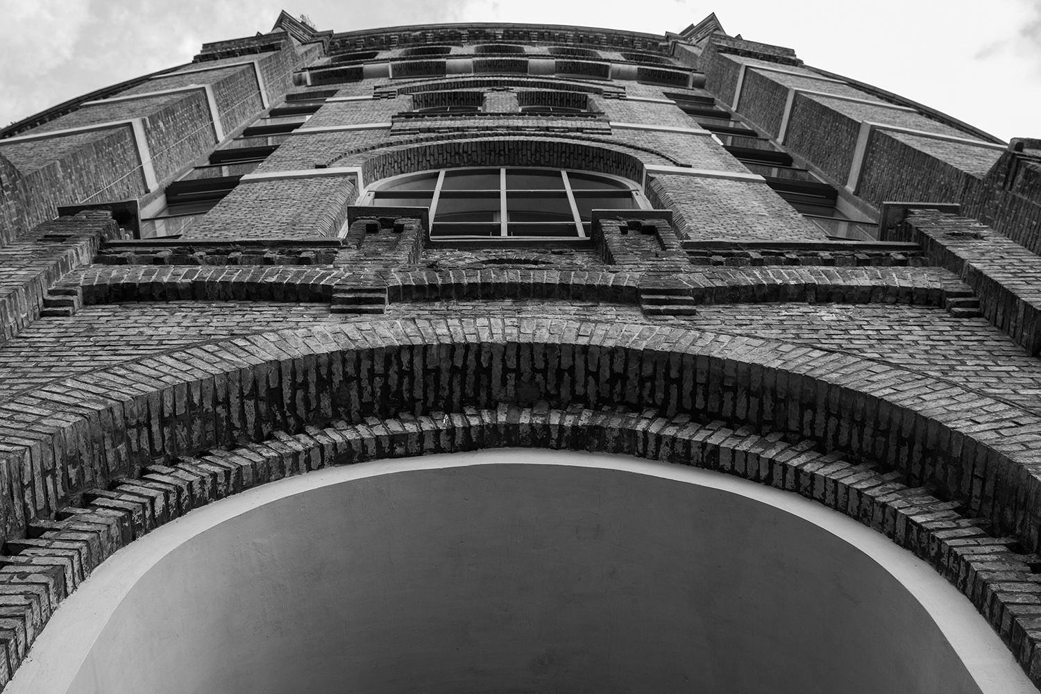 Backsteinfassade mit grossem Bogen, von unten fotografiert