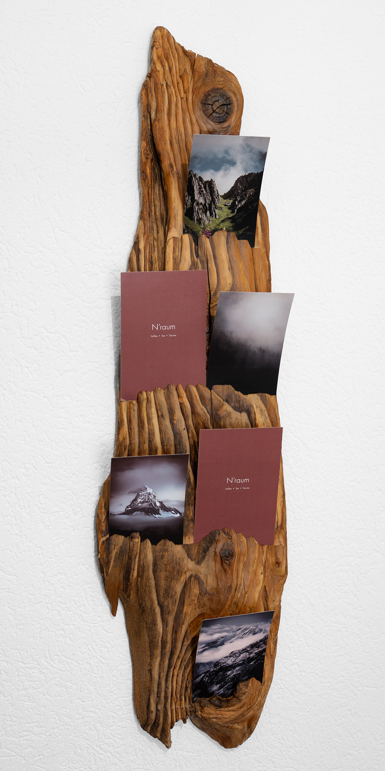 Holzregal mit Galeriekarten und Landschaftsfotografien