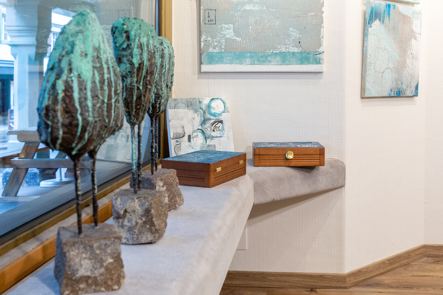Galerie-Ecke mit gerahmten Fotografien und Holzbank