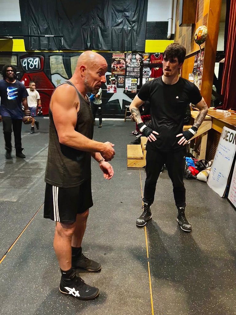 Coach Zac working with a member on the gym floor