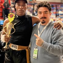 Fighter and coach celebrating with a trophy