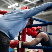 Corner man coaching a fighter between rounds