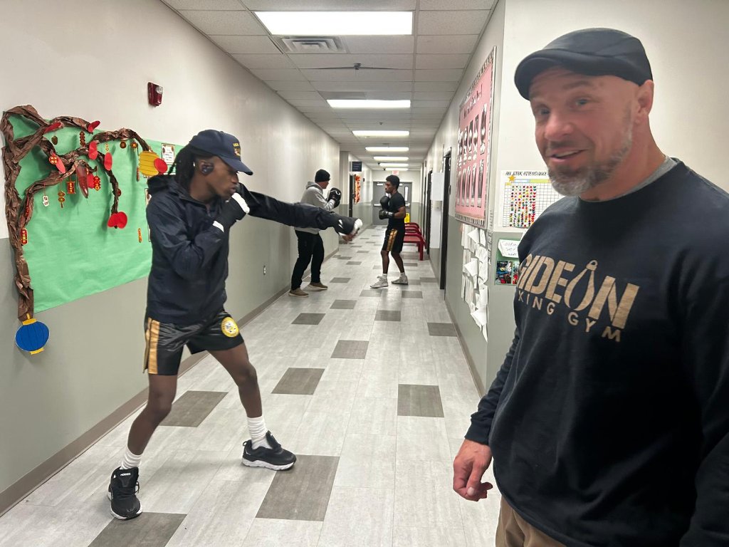 Coach Zac coaching in the gym hallway