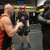Three-person sparring session in the gym