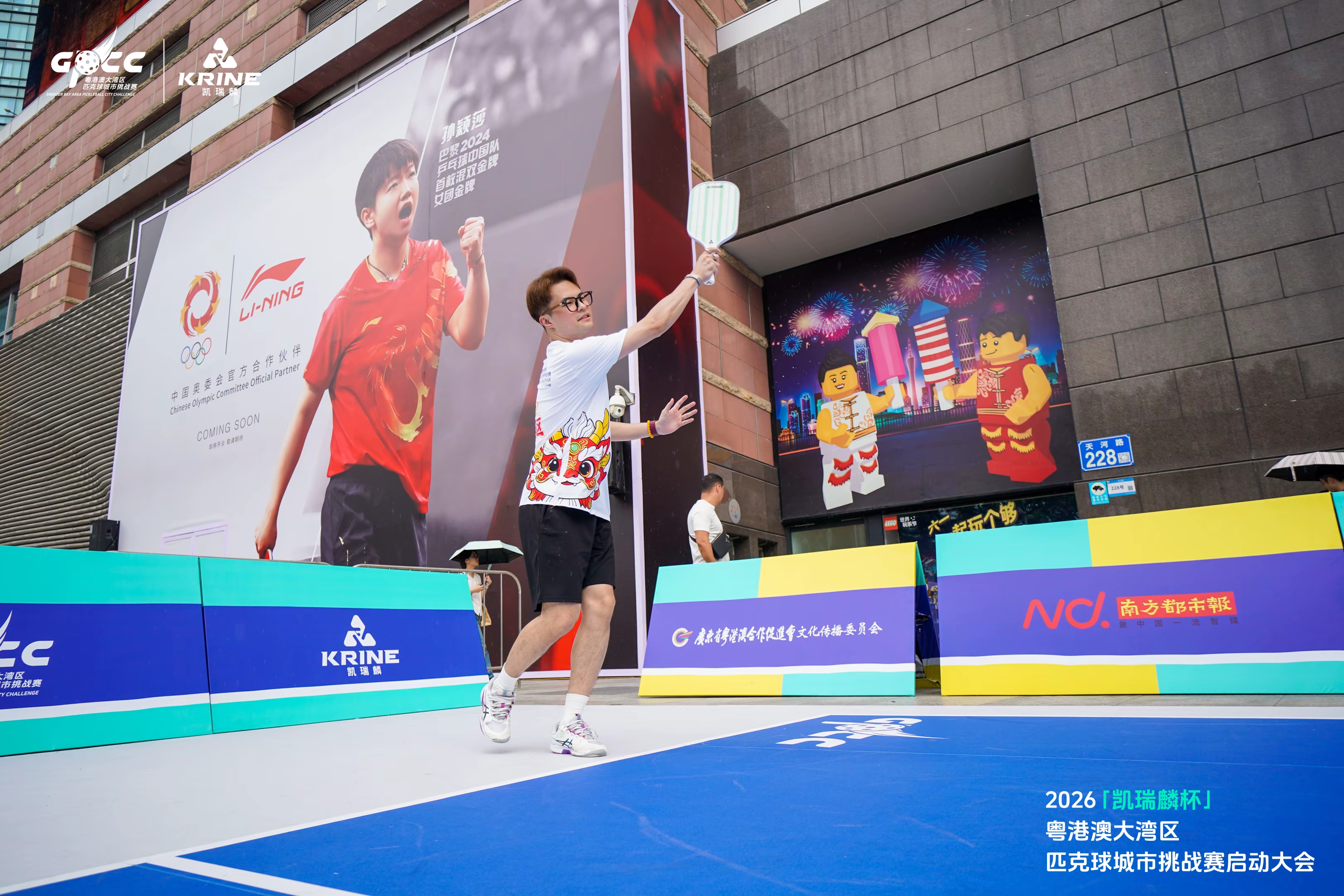 Pickleball demonstration outdoors with branded barriers