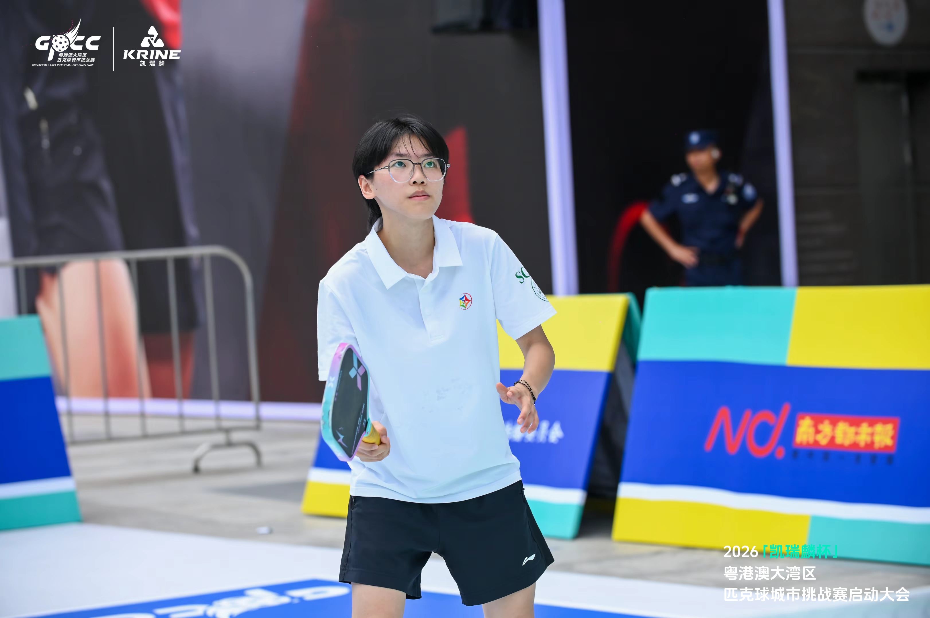 Young player focused on court with a pickleball paddle