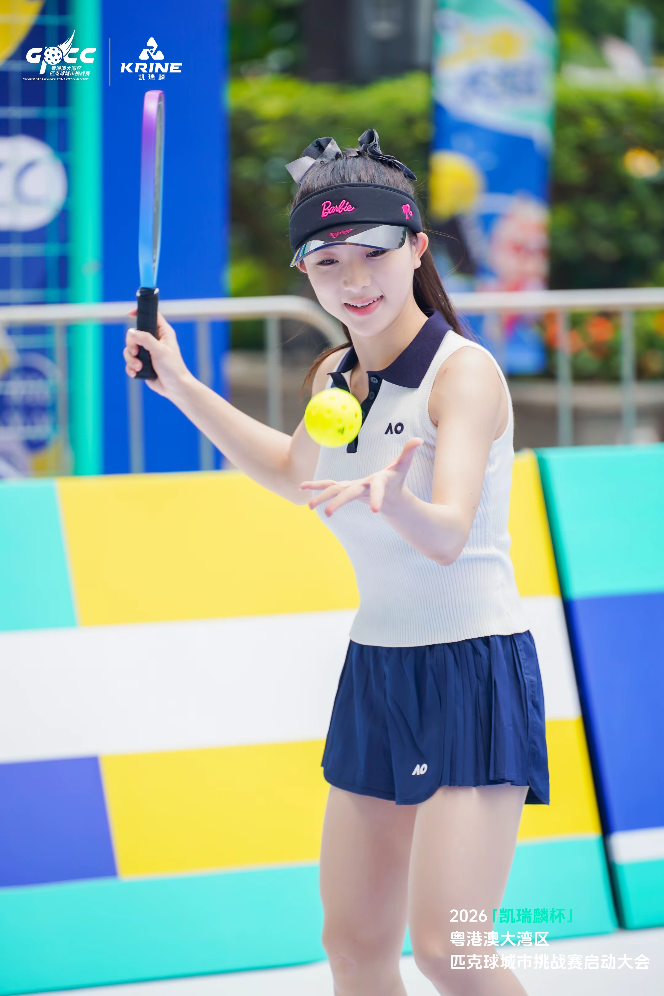 Young player tossing a pickleball on court