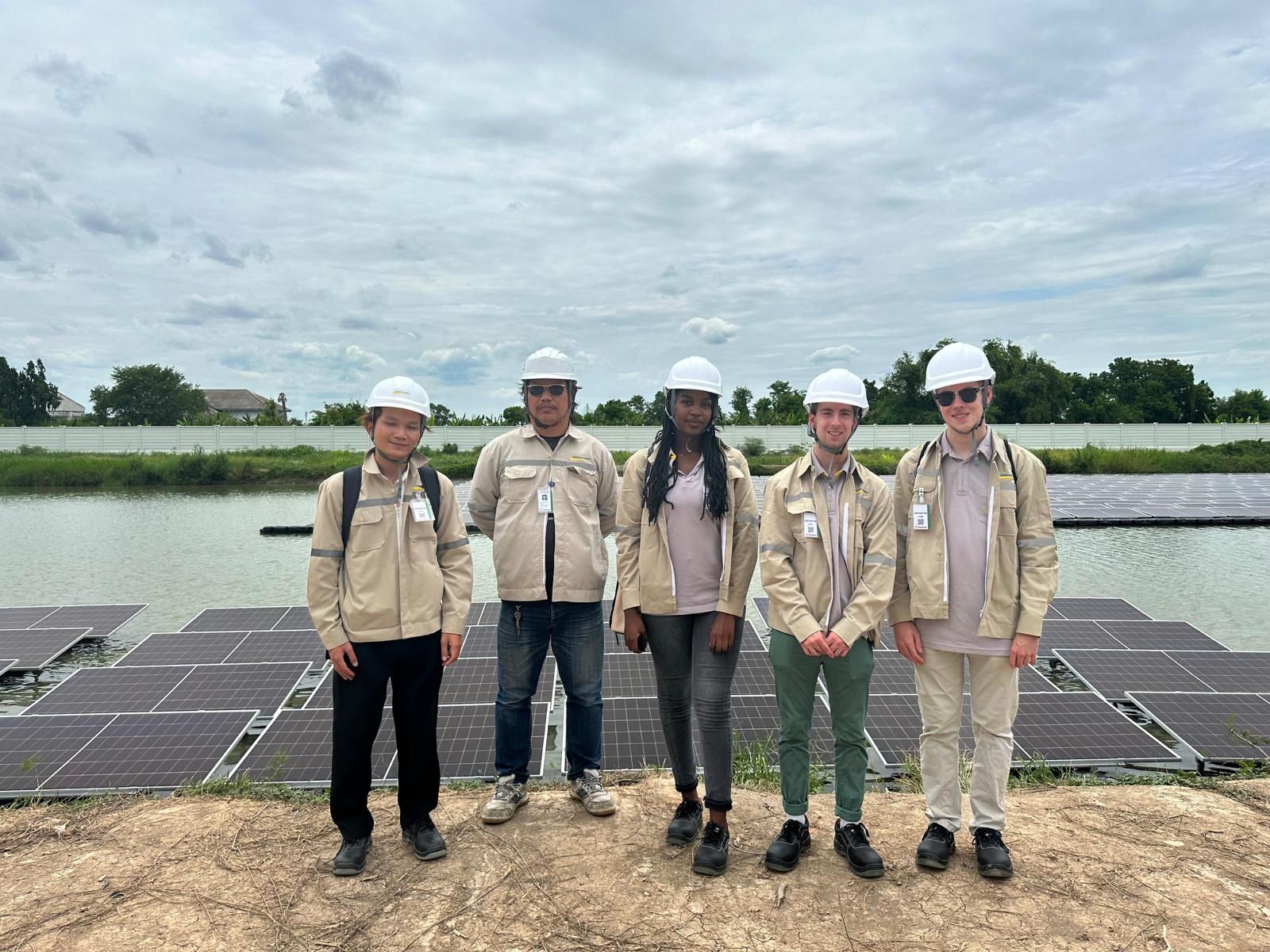 Workers in hard hats at a floating solar panel installation in Thailand