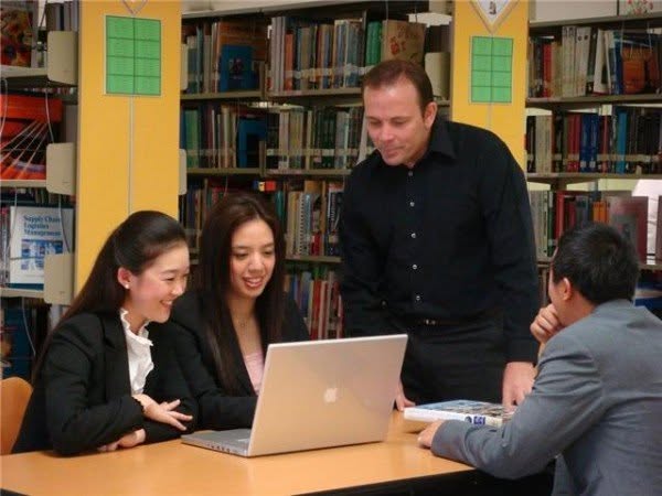 Group of students working together with a laptop in a study setting